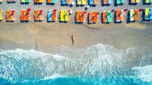 Aerial view of lying woman oThe Major Tourism Experiences Hardship Grant An Important Informationn the beach